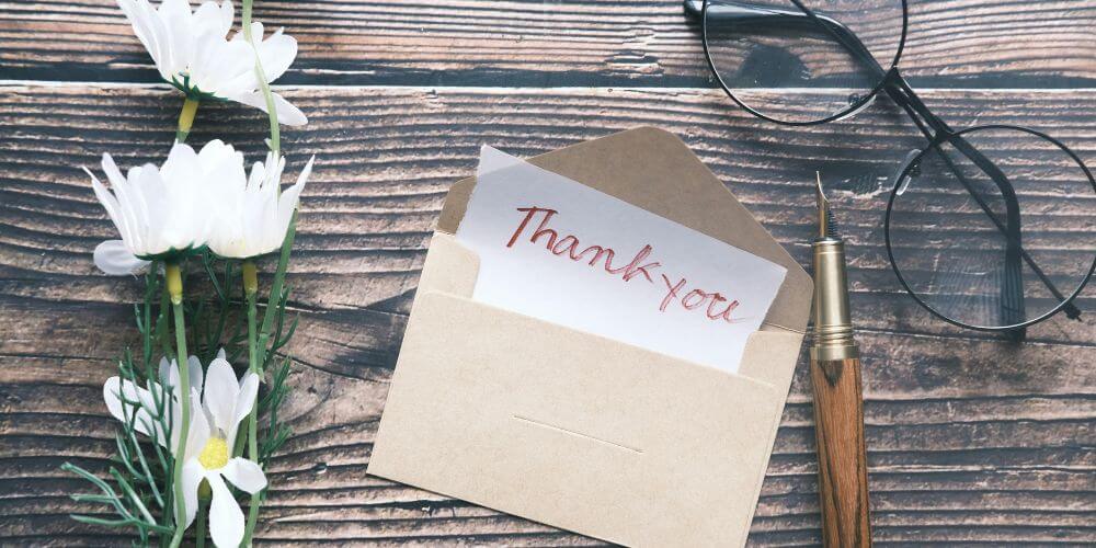 Opinia Oli po programie Kompas Kariery Plus Opinia Oli po Kompasie kariery - kartka z podziękowaniem, piórem, okularami i kwiatem